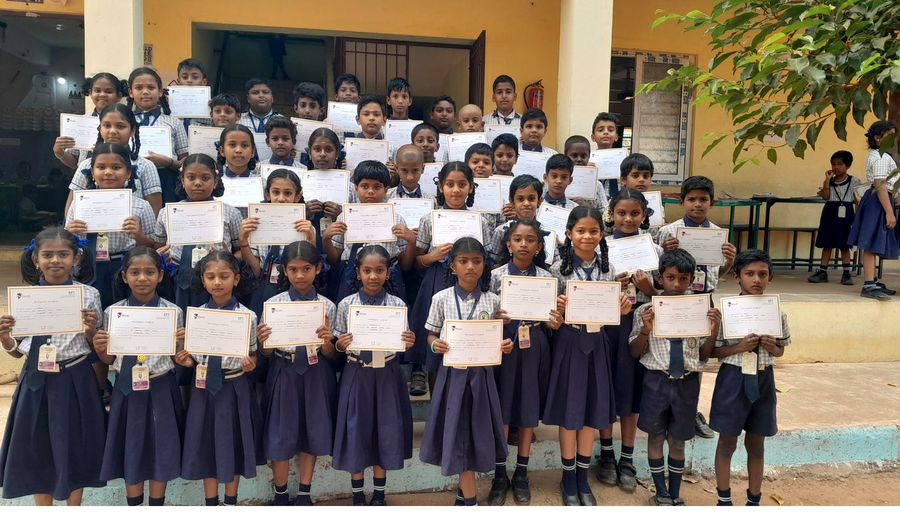 Students holding Olympiad certificates and medals